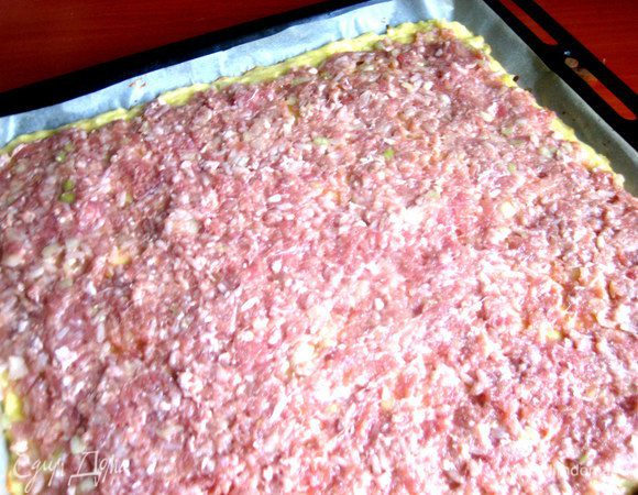 Распределяем по пласту весь фарш,оставляя место для склеивания.