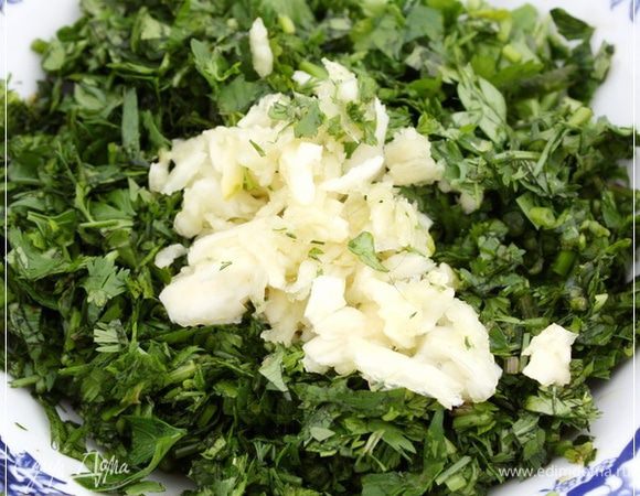 И исполним пару (хотя тут дело вкуса) зубчиков прямо в плошечку с мелко нарубленной зеленью. Из которой мы потом.… Да, чеснок можно и давить давилкой и толочь толкушкой или порубить мелко. Но мне нравится – когда толкушкой.
