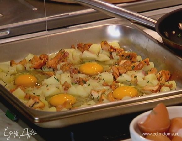 Вынуть противень с картофелем из духовки, выложить сверху обжаренные лисички с луком, все перемешать, лопаткой сделать четыре углубления и разбить в них яйца.