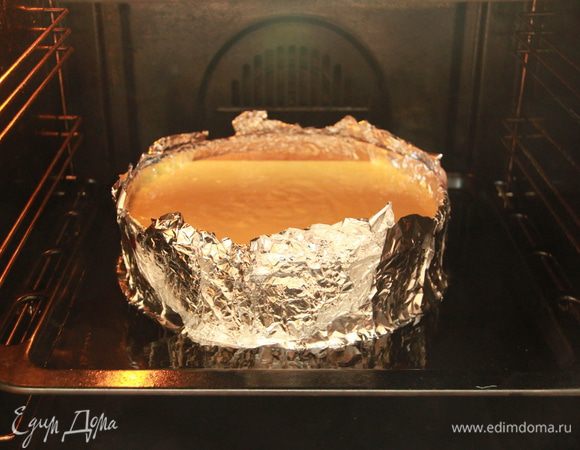Форму обернуть двумя слоями фольги. Поставить форму на противень/поддон с высокими бортиками. Налить в противень/поддон кипятка до половины формы с кейком. Выпекать при 160*С примерно 1,5 часа.