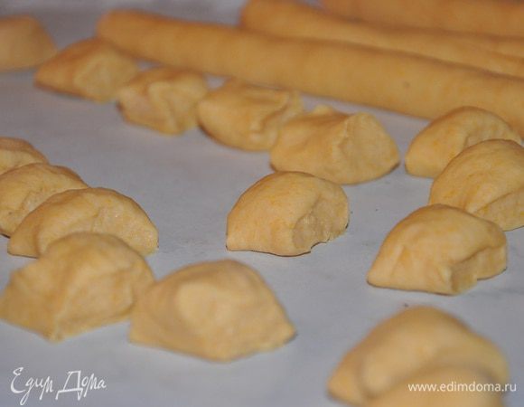 Разделить тесто на части, раскатать каждую часть в жгутики и разделить на кусочки.
