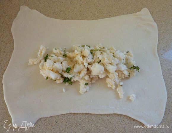 В центр прямоугольника  положить около столовой ложки сырной начинки.
