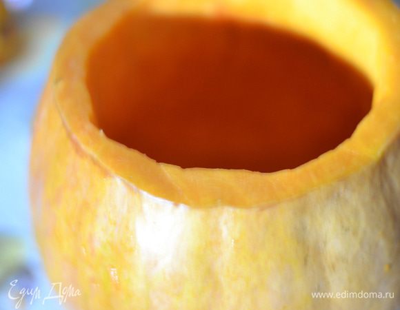 Достаньте тыкву из духовки. Нафаршируйте начинкой из риса и мяса, влейте немного воды, добавьте несколько зубчиков чеснока, небольшое количество сливочного масла.