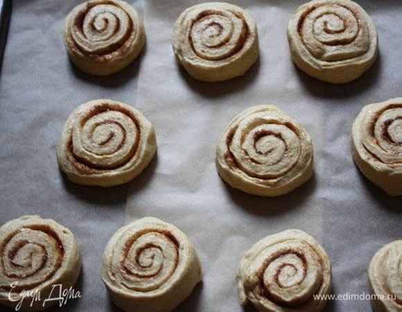 Скатать рулет и нарезать на порционные булочки. Свободно распределить булочки на противне. 
Накрыть  пленкой и дать булочкам увеличиться в размере в 2 раза. Из этого количества теста у меня получилось 12 булочек.