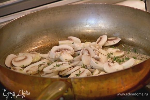 Разогреть в сковороде оливковое масло, выложить грибы, посолить, поперчить, посыпать листьями тимьяна, перемешать и обжаривать 3–4 минуты.