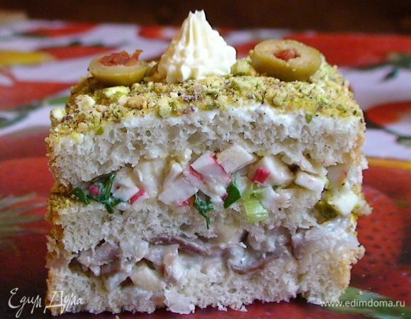 На 4 ломтика хлеба выложить селедочную смесь, сверху поместить еще по ломтику хлеба и распределить крабовую смесь.  Оставшиеся ломтики положить на крабов и смазать сливочным сыром.  Каждый «тортик» разрезать напополам. При желании обмазать сливочным сыром бока. Посыпать измельченными фисташками и украсить «цветочками» из сливочного масла, выдавленных кондитерским шприцом, и кружочками маслин.