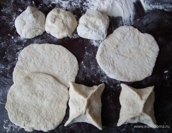 Когда тесто подойдёт, разделить на шарики с грецкий орех и раскатать на тонкие круглые сочни.
Сделать четырёхугольные пирожки и выпекать в духовом шкафу 20-30 минут.