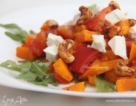 На тарелку выложить рукколу, затем тыкву с перцами, выложить сыр фета, разломленный руками на небольшие кусочки. Украсить поджаренными орехами. Сверху полить соусом для овощей. Подавать тёплым. Приятного аппетита!