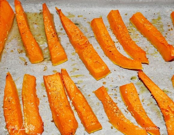 Тыкву очистите от семян и кожуры, нарежьте ломтиками. На противень, застеленный бумагой для выпечки, выложите тыкву, сбрызните маслом, посыпьте орегано и розмарином, запеките в разогретой до 200°C духовке, пока тыква не станет мягкой.