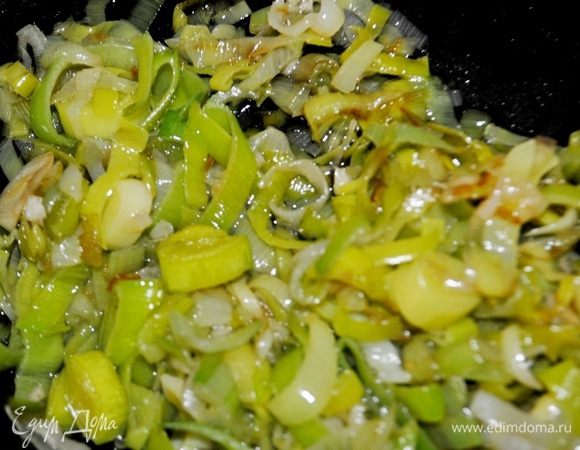 Лук-порей нарежьте колечками, измельчите чеснок. В сковороде разогрейте растительное масло и обжарьте лук и чеснок, помешивая, 6–7 минут.