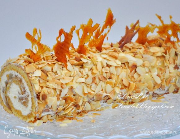 Затем достаем рулет, освобождаем от пергамента. Смазываем рулет кремом, который мы отложили. Рулет присыпаем лепестками миндаля. Лепестки можно оставить белыми, а можно, как я подсушить на сухой сковородке, и тогда они приобретут золотистый цвет. Я еще украсила фигурками из карамели. Приятного аппетита!!!!!!!!!!!!!!