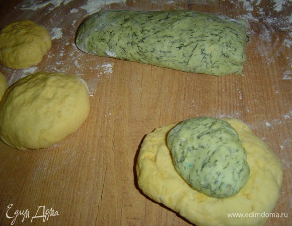 После того как тесто подошло приступаем к формовке хлеба. Отщипываем от тыквенного теста кусочек побольше, а от укропного поменьше и скатываем его в шар. Из тыквенного теста сделать лепешку, в центр положить шарик укропного теста, а затем соединить концы тыквенного теста и защипать. Этот шар кладем на противень, застеленный пергаментом.