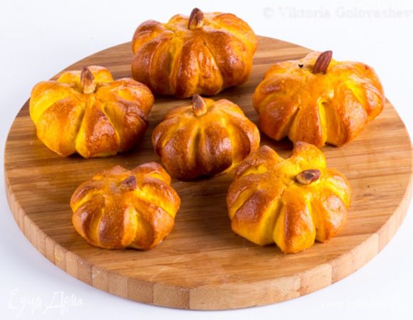 Оставьте подниматься на 1 час под полотенцем, после чего смажьте каждую булку яичной глазурью (из оставшегося яйца и щепоткой соли) и вставьте в центр кусочки орешков, имитируя черешок тыквы. Выпекайте в разогретой до 190°C духовке 8–10 минут, пока корочка не станет золотистой.