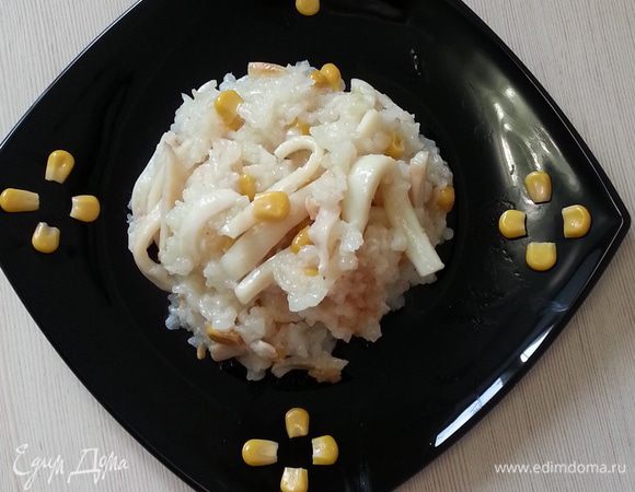 Мультиварка, в процессе работы на программе "Рис", начинает обратный отсчет, когда до завершения остается 10 минут. В этот момент, открываем ее, добавляем кальмары, кукурузу, измельченный чеснок, соль и 50 мл. воды, перемешиваем. После отключения даем настояться минут 10.