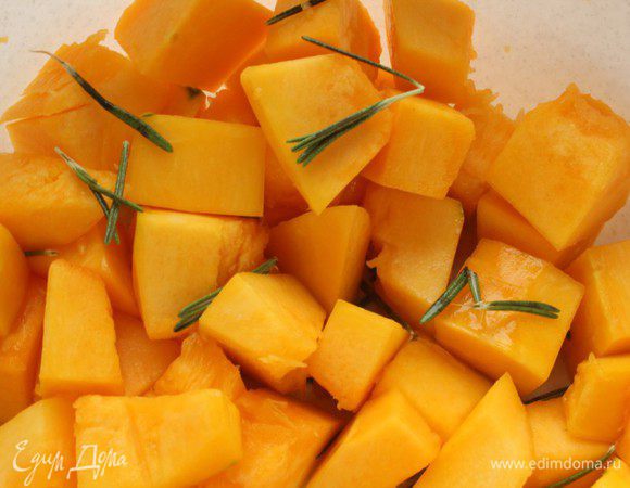 Тыкву нарезать небольшими кубиками, посолить, полить оливковым маслом, посыпать розмарином и перемешать.