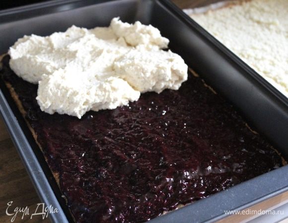 Уложить в форму или на противень один корж и смазать его джемом. Поверх джема выложить 2/3 крема. Разровнять и накрыть вторым коржом. Покрыть пляцок оставшимся кремом и убрать в холодильник.