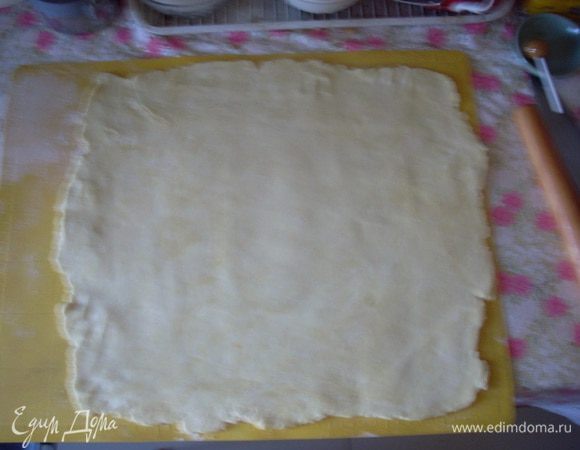 Делю тесто на 2 части (одна побольше - для нижнего пласта). Раскатываю нижний пласт размером 40х35 см (я предпочитаю раскатывать на силиконовом коврике - так удобнее переносить пласты на противень). Противень не смазываю - тесто довольно жирное. Нижний пласт укладываю на противень.
