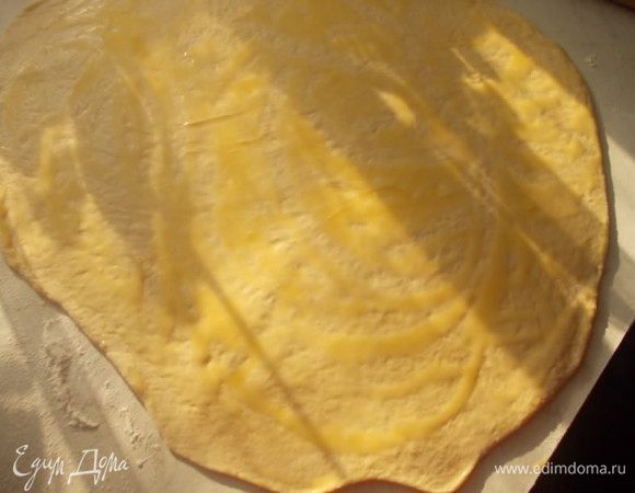 После того, как тесто подошло, раскатать его на столе. Тонко, но без фанатизма, чуть толще, чем на вареники. Смазать его растопленным маслом или маргарином.