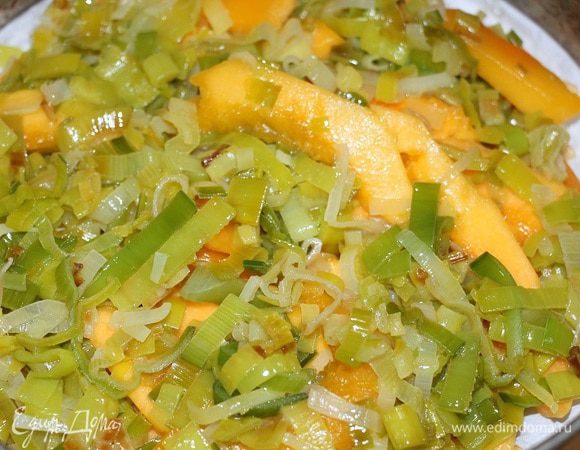 Сверху выкладываем плотно друг к другу кусочки тыквы, затем лук порей.