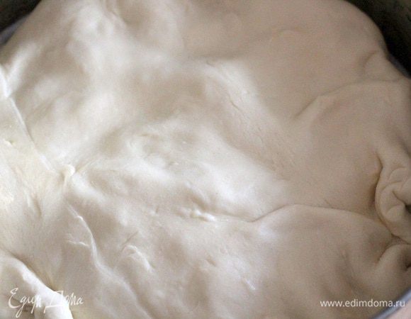 Накрываем кругом слоеного теста большего диаметра, чем форма. Свободные края теста заворачиваем внутрь так, чтобы они легли между обжаренными овощами и стенкой формы, образовывая бортики.