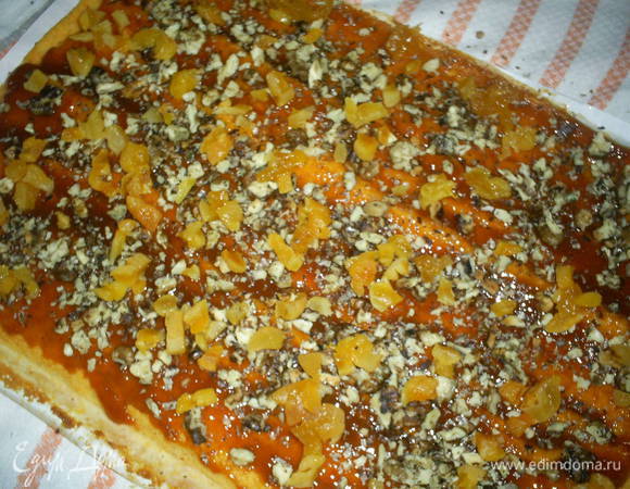 Для начинки курагу зальем кипятком на 10 минут, затем промоем, просушим и мелко нарежем. Орехи крупно порубим.
Готовый бисквит еще горячим смазываем джемом, посыпаем курагой и орехами и сворачиваем рулетом при помощи полотенца и бумаги, на которой выпекался бисквит.