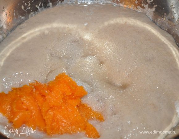 После того, как опара поднимется, влить теплое молоко, тыквенное пюре, добавить масло, желтки, оставшийся сахар, муку 