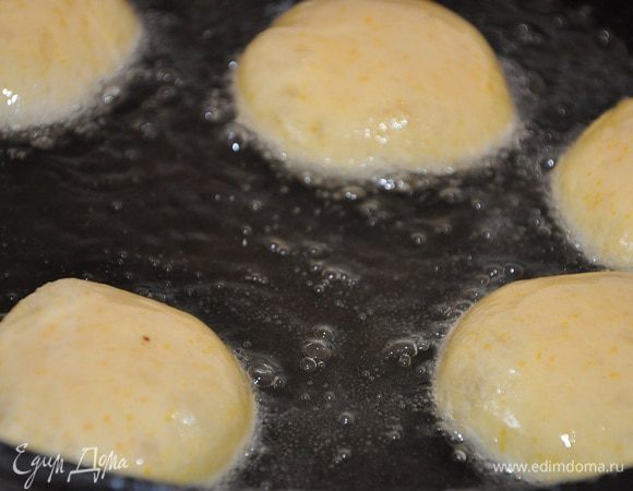 Нагреть в казане масло и поджарить пончики до золотистого цвета.