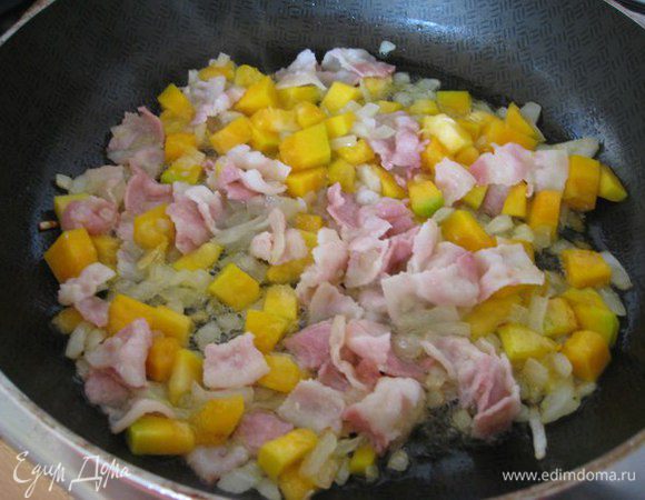 В сковородке разогреть 5 столовых ложек оливкового масла, добавить лук, лук приготовить до прозрачности.
Добавить тыкву, бекон, посолить, увеличить огонь,жарить 3-4 мин,постоянно помешивая.