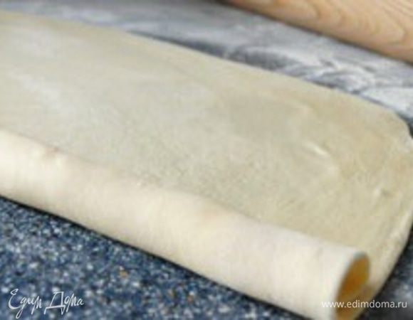 Раскатайте тесто в очень тонкий пласт и смажьте растопленным жиром по всей поверхности.