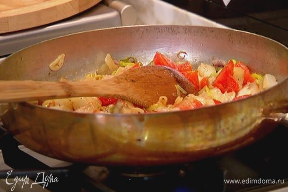 Добавить баклажан в сковороду с помидорами и луком, влить оставшееся оливковое масло, посолить, поперчить и прогревать все на огне пару минут.