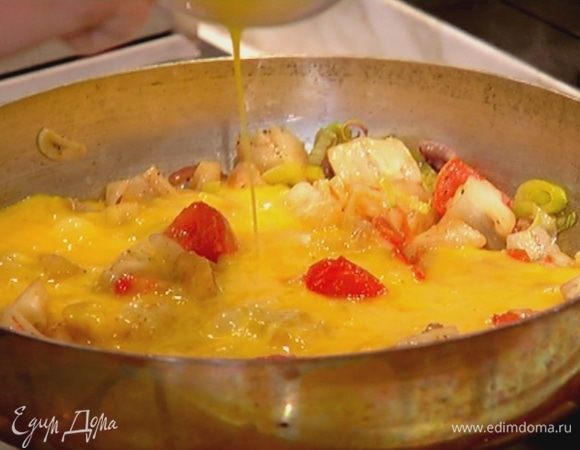 Яйца посолить, поперчить, взбить венчиком, влить в сковороду с овощами и посыпать все натертым сыром. Жарить омлет, слегка помешивая у краев, чтобы он не получился сухим.