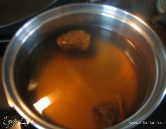 Грибы замочить в холодной воде на несколько часов. Тщательно промыть залить водой и отварить до полуготовности.  Грибы достать из бульона и порезать на небольшие кусочки.