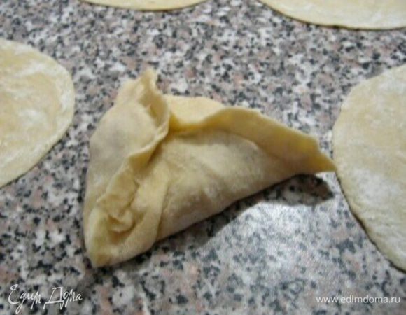 На каждую лепешку выкладываем начинку, защипываем края и выкладываем на противень швом вниз.