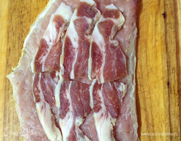 На отбитое мясо выкладываем слайсы пармской ветчины. 