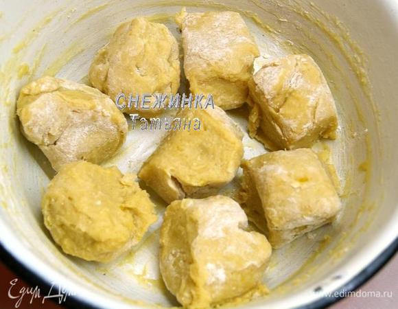 Испечём коржи. Тесто достаём из холодильника, оно станет густым, но остаётся слегка липким. Вываливаем его на присыпанную мукой рабочую поверхность. Формируем колбаску и делим её на 8 равных частей.