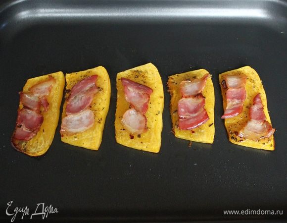 Поместите противень в разогретую до 200 градусов духовку на 10-15 минут, т.е. на время, в течение которого бекон зарумянится и тыква зепечется.