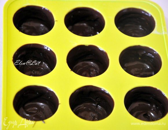 Теперь берем формочки для конфет и с помощью плоской кисточки наносим шоколад по бокам и дно будущей конфетки. Отправляем в холодильник на 10 минут. Затем опять повторяем манипуляцию смазывания стенок и дна. И снова в холодильник на 5 минут. 