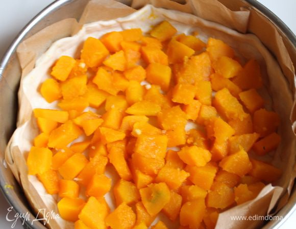 Из теста вырезаем круг, диаметром нашей формы. У меня 24 см. Берем бумагу, выкладываем ее в нашу форму и кладем сразу тесто. Из остатков теста нарезаем полоски и делаем бортики. Выкладываем нашу тыкву.