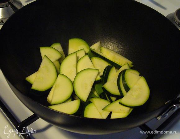 На разогретой сковороде (у меня вок для быстроты исполнения - завтрак всё-таки) обжариваем цукини с добавлением оливкового масла.