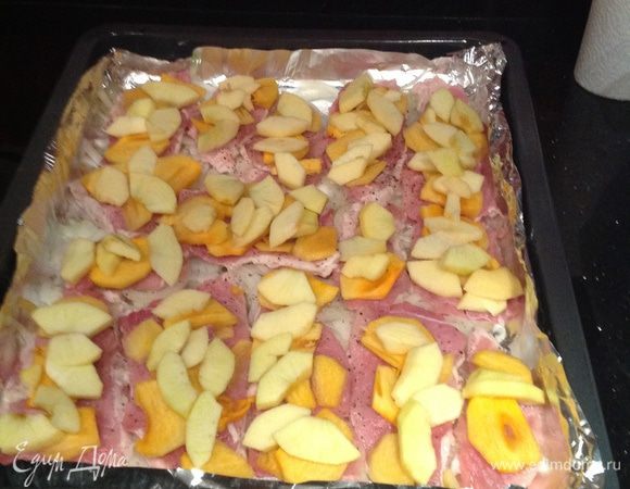 Яблоки и хурму очистить от кожуры. У яблока удалить сердцевину. Вытащить косточки из хурмы. Нарезать дольками. Уложить на мясо чередуя.