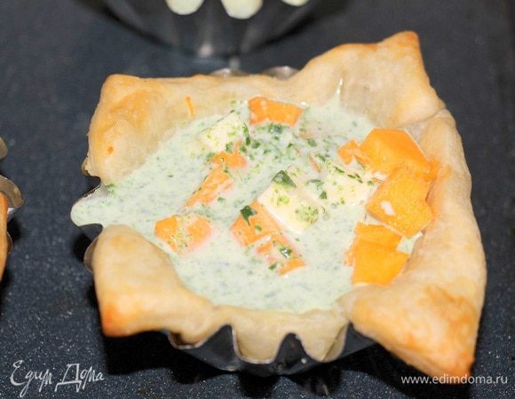 В подготовленные тарталетки выложить кубики тыквы и феты, залить шпинатно-сливочной смесью.