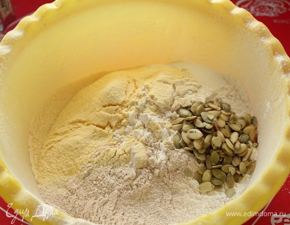 Просеить всю муку, добавить соль,сахар, обжаренные тыквенные семечки.