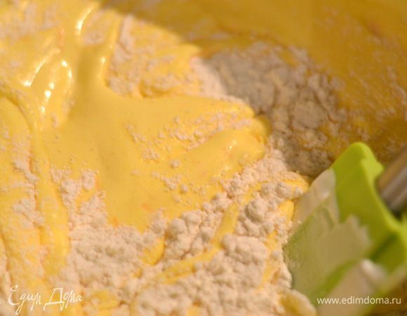 Добавить во взбитые желтки с тыквой половину просеянной муки и лопаткой перемешать.