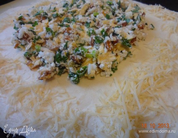 Размороженное тесто раскатать в пласт 5-6 мм толщиной, переложить на смазанный лист или с пергаментом (у меня силик. коврик). На середину выложить начинку, оставляя несколько сантиметров от всех краев. По всему периметру выложить тертый пармезан.