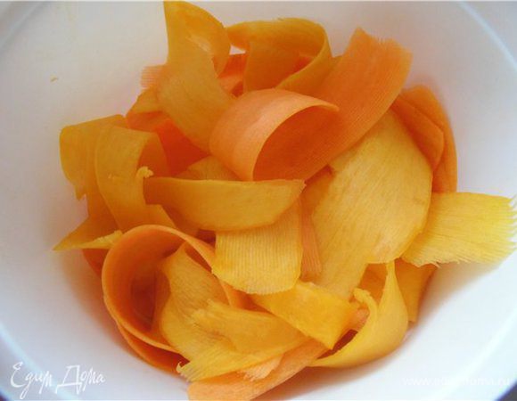 Сырые тыкву и морковь натереть с помощью овощечистки.