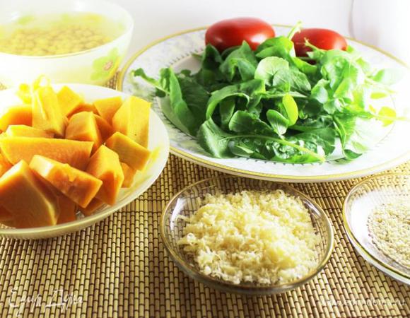 Нут предварительно замочить на 2 - 3 часа. После варить до готовности, остудить.
Тыкву порубить на средние кусочки. Запечь в разогретой до 170 градусов духовке (примерно 20 минут). Руколу помыть и просушить. Кунжут немного поджарить на сухой сковороде (1 минуту). Помидоры ошпарить кипятком и снять кожицу. Порезать средними кусочками. 