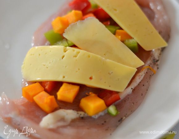 На филе выложить овощи, сыр порезать на полоски, выложить сверху на овощи.