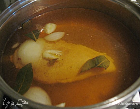 Налейте в кастрюлю воду и доведите до кипения. В кипящую воду положите специи, чеснок, лук, можно положить кусочек сельдерея. Посолите, добавьте перец по вкусу. В кипящую воду со специями опустите грудку, закройте крышкой и варите на медленном огне 5 минут. Выключите огонь, положите теплое полотенце на крышку и оставьте на 20–30 минут, не убирая с плиты.