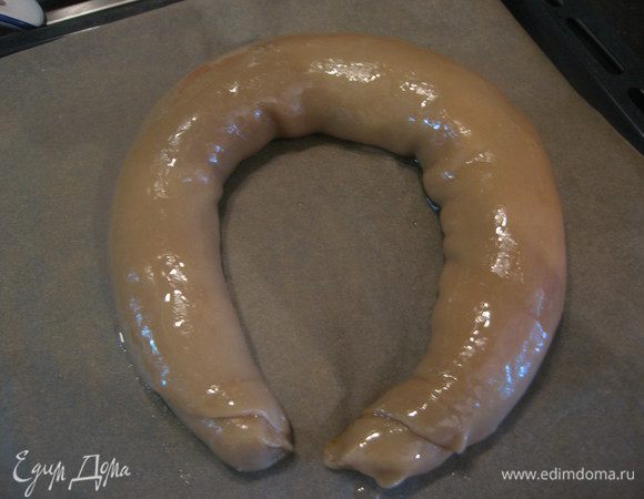 Укладываем на бумагу для выпечки, смазываем сверху растительным маслом, придаем форму подковы.