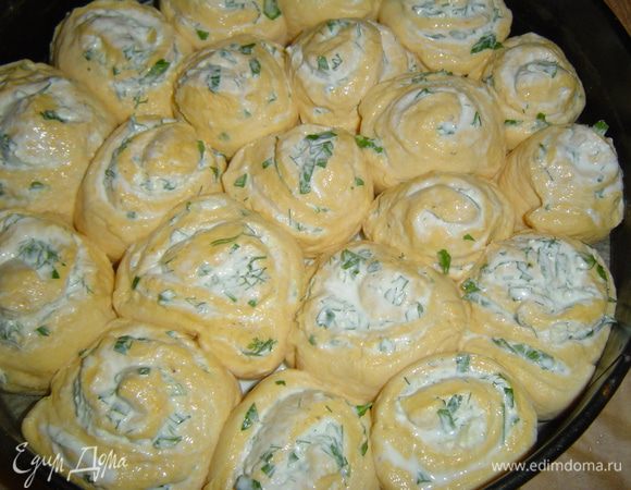 и ставим в форму, застеленную пергаментом, один к одному. Накрываем их полотенцем и даем постоять минут двадцать, затем поливаем их сверху из ложки молоком